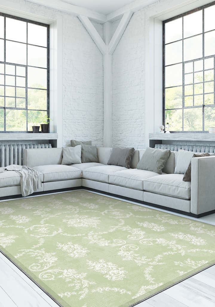 Modern living room with a light gray sectional sofa and a green patterned rug.
